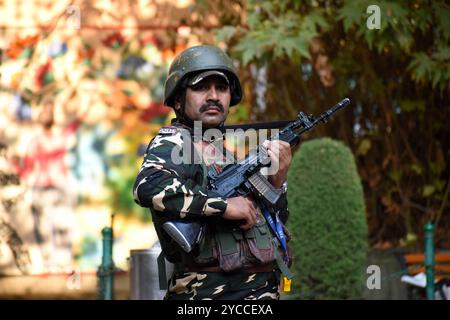 Srinagar, India. 22 ottobre 2024. Un ufficiale di sicurezza è di guardia che controlla diligentemente l'area circostante il 22 ottobre 2024, a Srinagar, Kashmir, India. Tragicamente, sette persone hanno perso la vita domenica quando i terroristi hanno aperto il fuoco in un cantiere nel distretto di Ganderbal, Jammu e Kashmir. Le autorità hanno confermato che tra le vittime c'era un medico del Kashmir, insieme a lavoratori e personale impiegati da un appaltatore che lavorava su un tunnel per l'autostrada nazionale Srinagar-Leh. (Foto di Danish Showkat/Sipa USA) credito: SIPA USA/Alamy Live News Foto Stock