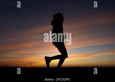 Magonza, Renania Palatinato, Germania. 22 ottobre 2024. Una donna fa jogging su una collina al tramonto a Magonza, in Germania. (Immagine di credito: © Matias Basualdo/ZUMA Press Wire) SOLO PER USO EDITORIALE! Non per USO commerciale! Foto Stock