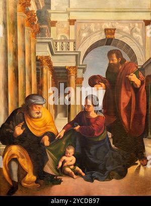 PAVIA, ITALIA - 8 SETTEMBRE 2024: Il dipinto rinascimentale del Santo Famili con San Barnaba nella Cattedrale del Maestro Sant'Agnese Foto Stock