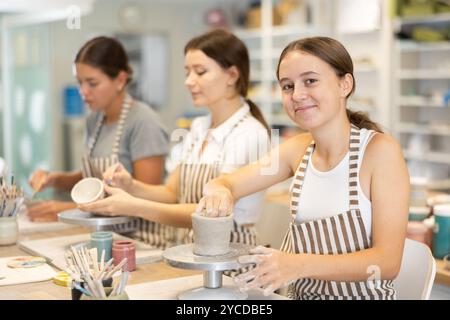 Durante la master class, una studentessa adolescente scolpisce l'argilla Foto Stock