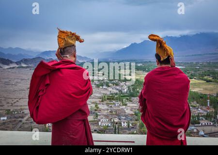 Due monaci buddisti tibetani che soffiano conches durante la mattina pooja, Thiksey gompa, Ladakh, India Foto Stock