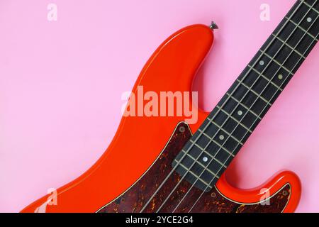 Basso elettrico rosso su sfondo rosa. Immagine ravvicinata. Foto Stock