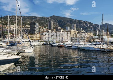 Stupenda vista mattutina su barche e yacht (barche a vela) nel porto di Hercule e negli edifici di Monaco e Monte Carlo nella giusta direzione con hotel e casinò bui Foto Stock