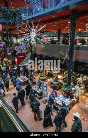 12-23-2023 BERLINO nel negozio di prenotazione prima di Natale persone che fanno gidts (forse per se stesso o per se stesso), camminano e leggono (scegliendo) all'interno di perf Foto Stock