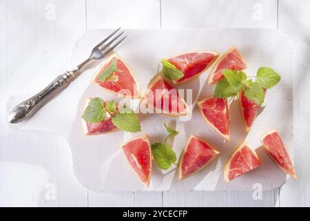 Presentazione sul rosso taglio Segmenti di pompelmi e di pomeli Foto Stock