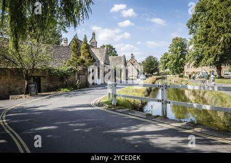 LOWER SLAUGHTER, UK, 12 AGOSTO 2015: River in the Village a Blue Sky day. La macellazione inferiore è nota per i suoi cottage calcarei nelle tradizionali culle Foto Stock