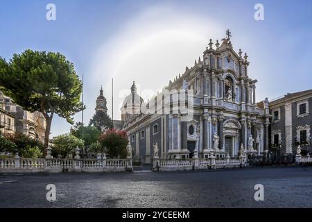 Basilica della Cattedrale di Sant'Agata con cespugli fioriti : bianco e rosso in giardino vicino a =Alba al mattino nel centro di Catania Foto Stock