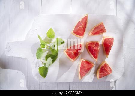 Presentazione sul rosso taglio Segmenti di pompelmi e di pomeli Foto Stock