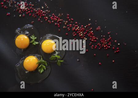 Presentazione di fresco e uova crude sul pavimento nero di pomice Foto Stock