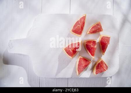 Presentazione sul rosso taglio Segmenti di pompelmi e di pomeli Foto Stock