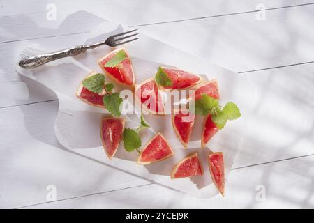 Presentazione sul rosso taglio Segmenti di pompelmi e di pomeli Foto Stock