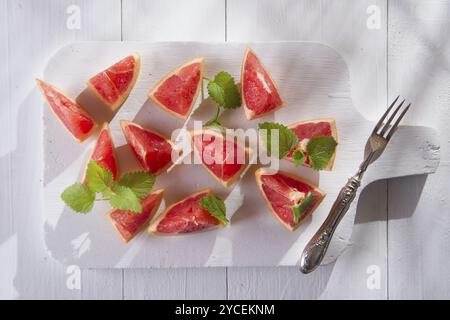 Presentazione sul rosso taglio Segmenti di pompelmi e di pomeli Foto Stock