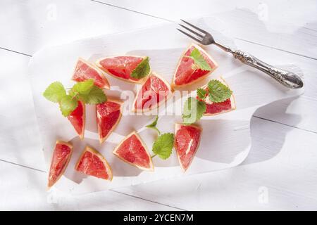 Presentazione sul rosso taglio Segmenti di pompelmi e di pomeli Foto Stock