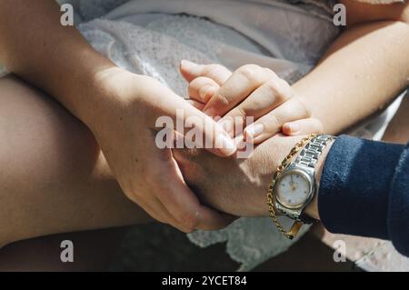 Mani di madre e figlia che si tengono insieme mostrando amore e gratitudine Foto Stock