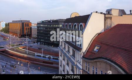 Panorama degli edifici vecchi e moderni al tramonto a Breslavia. Movimento sfocato persone a distanza percorribile a piedi. Tram in movimento Foto Stock