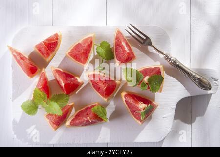 Presentazione sul rosso taglio Segmenti di pompelmi e di pomeli Foto Stock