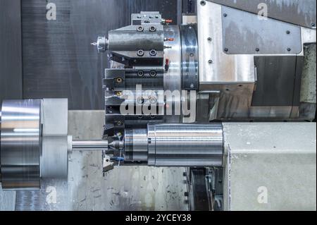 La macchina per tornio CNC che forma il taglio delle parti metalliche. Lavorazione dei metalli ad alta tecnologia mediante tornitura CNC, grafica Foto Stock