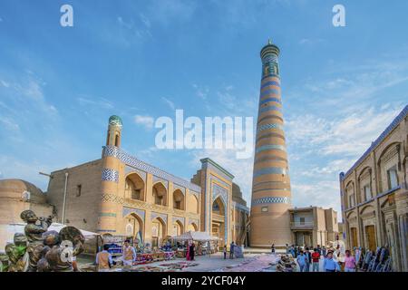 05-11-2022 Khiva Uzbekistan. Vista idilliaca del minareto Islam-Khoja e dei camerieri e degli uzbeki a piedi nella città vecchia di Khiva Foto Stock