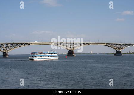 Un enorme ponte sul Volga a Saratov e una giornata di sole in barca da diporto in autunno Foto Stock