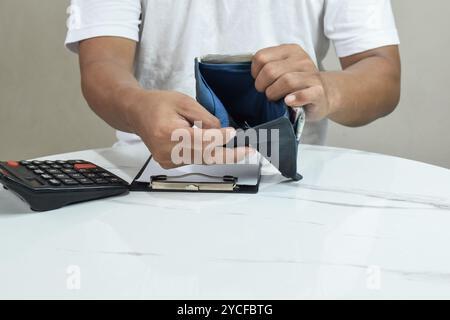 Concetto finanziario del debito, persone con problemi assistiti uomo asiatico, uomo aperto libero portafogli vuoto non avere budget di denaro per pagare senza avere carta di credito Foto Stock