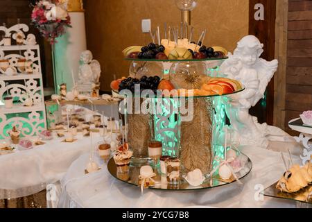 Elegante display da tavolo con dolci assortiti ed elementi decorativi. Foto Stock