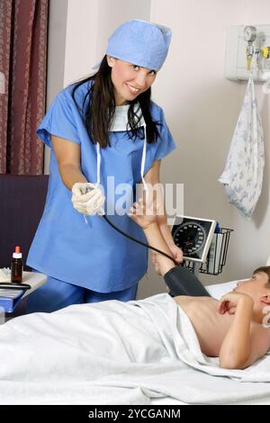 Misurazione della pressione sanguigna del paziente Foto Stock