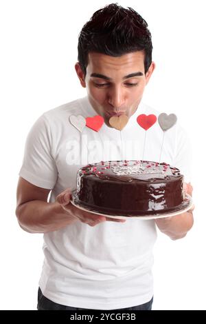 Uomo romantico bacio cuore su una torta Foto Stock