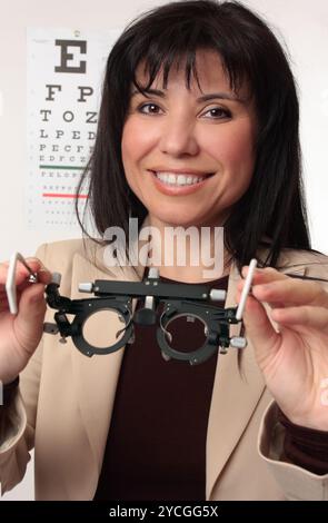 All'ottico optometrista holding telai di prova Foto Stock