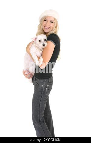 Donna felice che tiene il suo piccolo cane bianco Foto Stock