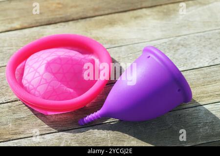 Prodotti igienici per donne ecocompatibili: Disco mestruale e tazza mestruale. Dispositivi riutilizzabili per la raccolta del sangue durante le mestruazioni Foto Stock