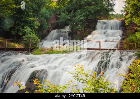 Serene cascate: Una tranquilla cascata circondata da una vegetazione lussureggiante. Foto Stock