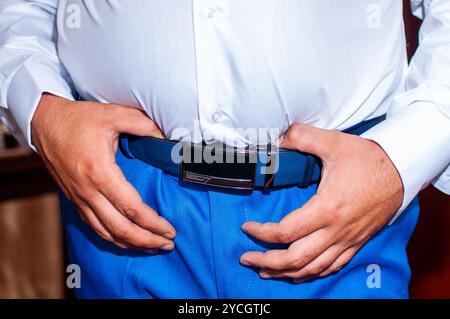 Un uomo elegante che indossa la cintura con un abbigliamento brillante. Foto Stock