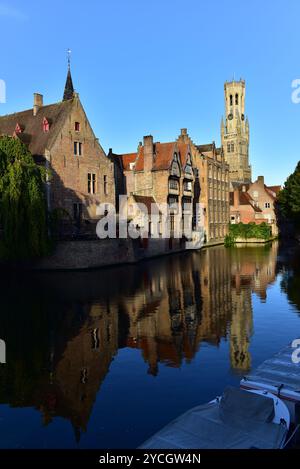 Belfry di Bruges, edifici medievali e la loro riflessione sul Canale di Dijver da Rosary Quay. Una mattina presto a Bruges, Belgio Foto Stock