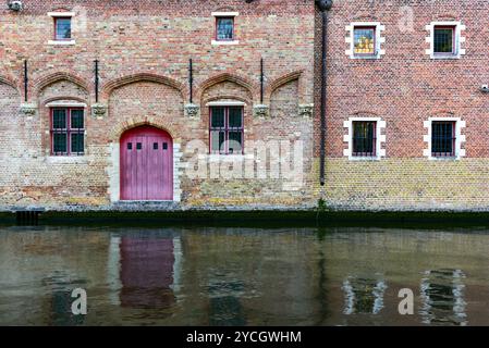 Edifici medievali in mattoni che costeggiano il canale Gronerei e il loro riflesso. Bruges, Belgio Foto Stock