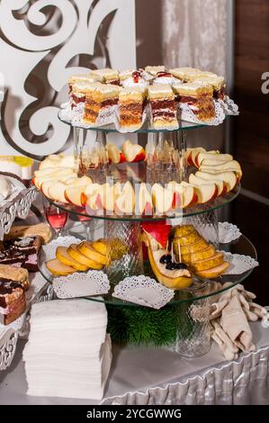 Squisita esposizione di dessert a più livelli con torte e frutta assortite. Foto Stock