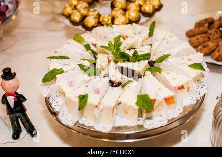 Squisito piatto di dessert con eleganti fette di torta e condimenti. Foto Stock