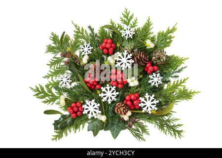 Decorazioni natalizie con fiocco di neve e vegetazione invernale. holly naturale, mietitura, edera, abete, coni di pino su sfondo bianco. Foto Stock