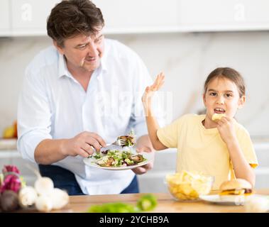 La figlia si rifiuta di mangiare cibo preparato dal padre Foto Stock