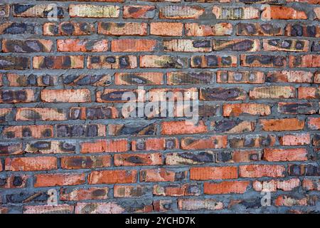 Weathered red un muro di mattoni come sfondo Foto Stock