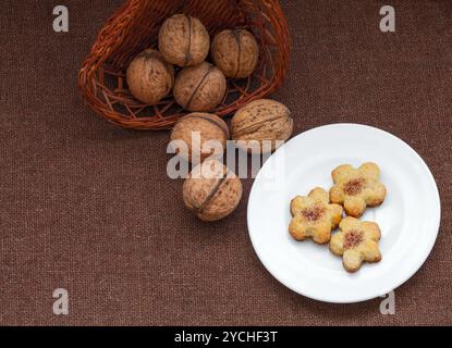 Cestello in vimini con noci e pasta su un piatto Foto Stock
