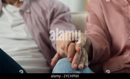 Primo piano due felici e irriconoscibili coppie sposate caucasiche in amore partner di famiglia uomo donna marito amorevole moglie che tiene per mano in casa Foto Stock