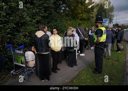 I passeggeri aspettano di entrare nell'aeroporto di Birmingham dopo che è stato evacuato in seguito a un allarme di sicurezza. Data foto: Mercoledì 23 ottobre 2024. Foto Stock