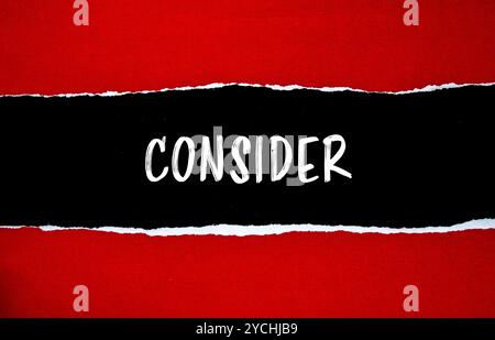 Considerare il messaggio scritto su carta strappata rossa con sfondo nero. Simbolo concettuale da considerare. Copia spazio. Foto Stock
