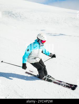 Sciatore esperto sulle piste d'inverno montagne innevate giorno di sole all'aperto spruzzo di carve neve. E istruttore di sci professionista Foto Stock