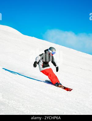 Sciatore esperto sulle piste d'inverno montagne innevate giorno di sole all'aperto spruzzo di carve neve. E istruttore di sci professionista Foto Stock