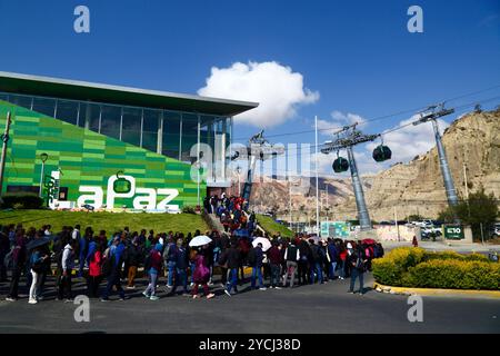 La Paz, BOLIVIA; 23 ottobre 2024: Un gran numero di persone fa la fila fuori dalla stazione della funivia della linea Verde di Irpavi nella zona Sur per raggiungere il centro di la Paz. Gli autobus e i minibus di la Paz sono in sciopero oggi per protestare contro la carenza di carburante e l'aumento del costo della vita. Le funivie sono la principale forma alternativa di trasporto durante tali scioperi. Le carenze di carburante e i problemi di approvvigionamento (in particolare il diesel) sono un problema regolare in Bolivia da diversi mesi; ci sono state anche enormi code per benzina/benzina dall'inizio della scorsa settimana. Foto Stock