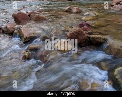 Acqua che scorre veloce sulle rocce nel letto del fiume Virgin nel Parco Nazionale di Zion, Utah Foto Stock