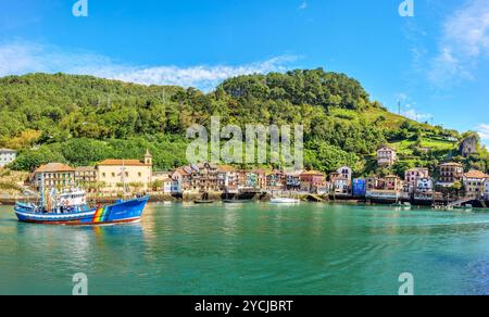 Una barca da pesca che attraversa la baia di Pasajes, di fronte al villaggio di pescatori di San Juan. Gipuzkoa, Paesi Baschi, Spagna. Foto Stock