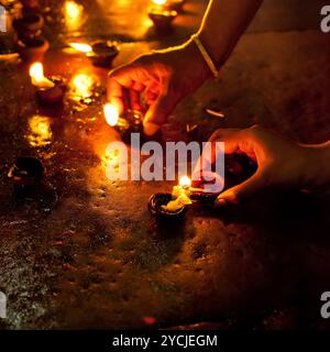 La gente la masterizzazione di lampade ad olio come rituale religioso in un tempio indù. India Foto Stock