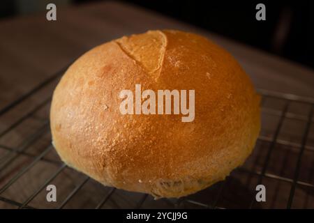 Classico pane bianco su una griglia. Questo panino rustico fatto in casa è realizzato con farina di grano bianco biologico per una ricetta a base di lievito madre. Foto Stock